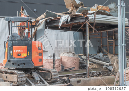 プレハブ小屋を解体する小型重機 106512087