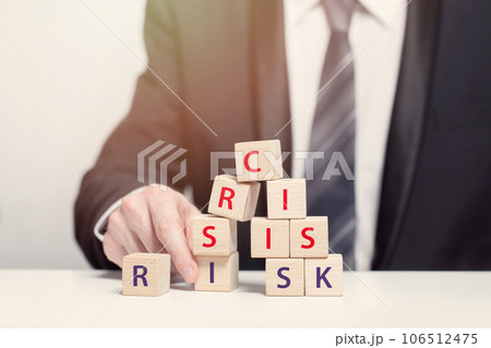 Wooden cubes with sign crisis, busimessman in suit, business financial loss, crisis and risk concept Wooden cubes with sign crisis, busimessman in suit, business financial loss, crisis and risk concept 106512475