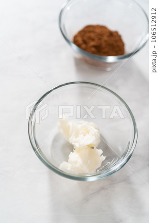 Greasing metal bundt cake pan with vegetable shortening and cocoa powder to bake gingerbread bundt cake with caramel filling. 106512912