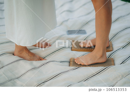 Standing on boards with nails. Young women practicing yoga and therapy in nature. Standing on boards with nails. Young women practicing yoga and therapy in nature. 106513353