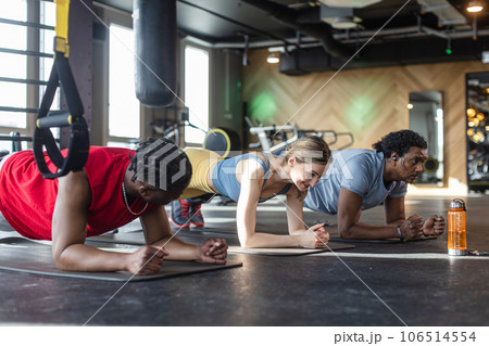 Three diverse people doing planks in gym Three diverse people doing planks in gym 106514554
