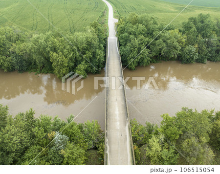 road and bridge over flooded Lamine River with floating debris, aerial view at Roberts Bluff access in Missouri 106515054