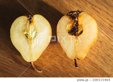 Damaged pears on wooden table. Peas with maggot on cutting board. Good and bad. Autumn farming. Difference concept. Raw food. Slices of sweet pear. Organic fruits. Spoiled fruits. Damaged pears on wooden table. Peas with maggot on cutting board. Good and bad. Autumn farming. Difference concept. Raw food. Slices of sweet pear. Organic fruits. Spoiled fruits. 106515464