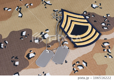 May 12, 2018. US ARMY Master Sergeant rank patch and dog tags on desert camouflage uniform 106516222
