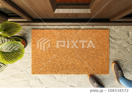 Overhead of blank doormat and shoes of a man standing on the porch at the front door. Overhead of blank doormat and shoes of a man standing on the porch at the front door. 106516572