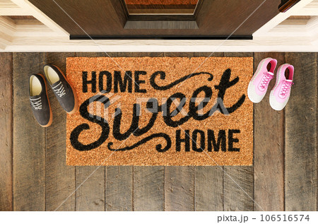 Home Sweet Home doormat with man and woman shoes on the porch at the front door. 106516574