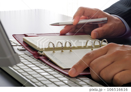 手帳で仕事の管理をするビジネスパーソン 手帳で仕事の管理をするビジネスパーソン 106516616