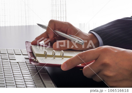 手帳で仕事の管理をするビジネスパーソン 106516618