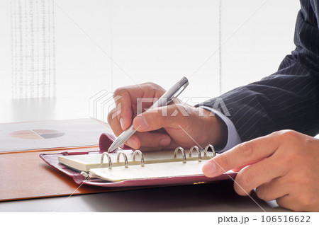手帳で仕事の管理をするビジネスパーソン 106516622