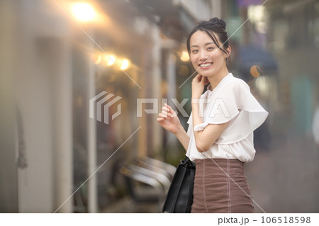 夕暮れの街でショッピングを楽しむ若い女性 夕暮れの街でショッピングを楽しむ若い女性 106518598