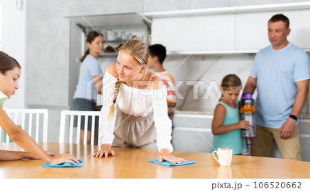 Teenage girls wash dining tables and help to do household chores, family day. 106520662