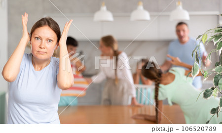 Wife is enraged by family conflict of teenage daughters with their father. 106520789