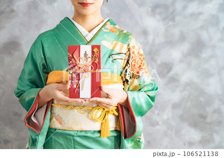 祝儀袋を持つ着物の女性 106521138