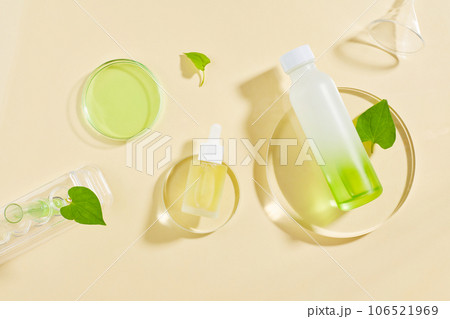 Fish mint leaves decorated with cosmetic container and a glass petri dish of green fluid. Fish mint (Houttuynia cordata) is full of medicinal properties 106521969