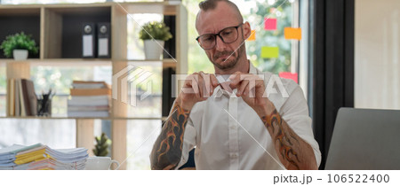 Stressed caucasian male business holding credit card making online payment on desk 106522400