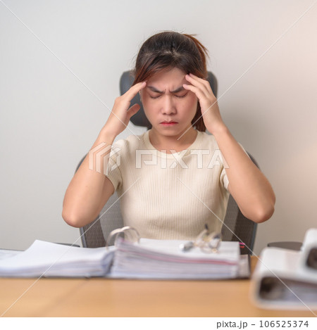 female businesswoman having headache and Migraine at office, Asian woman having Tired and Stressed while working, Exhausted woman with document folder stack at home late night. Overworked and Overtime female businesswoman having headache and Migraine at office, Asian woman having Tired and Stressed while working, Exhausted woman with document folder stack at home late night. Overworked and Overtime 106525374