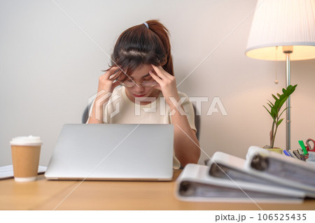 Stressed and Tired Asian woman while working, female businesswoman using laptop with headache, Migraine and Sleepy at office, Exhausted woman with computer at home late night. Overload and Overworked Stressed and Tired Asian woman while working, female businesswoman using laptop with headache, Migraine and Sleepy at office, Exhausted woman with computer at home late night. Overload and Overworked 106525435