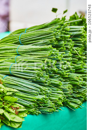 Ends of green onion or chives sticking outward from top of crowded table 106528748