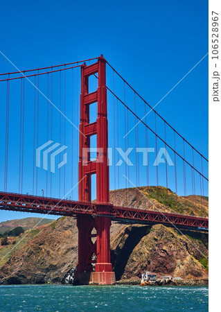 Close up of Golden Gate Bridge with bright blue sky and choppy bay waters 106528967