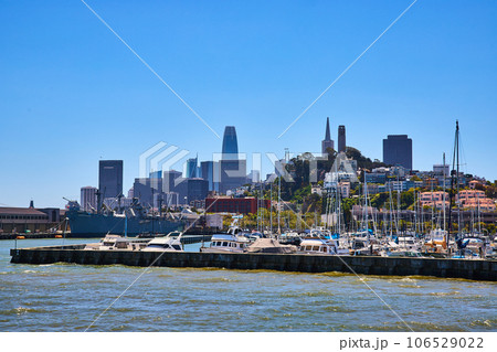 View of San Francisco downtown skyscrapers and Coit Tower from bay with boats docked at pier 106529022