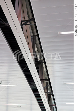 Abstract view of ceiling with metal slats and a single double metal beam 106529617