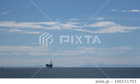 日本海に浮かぶ佐渡ヶ島と岩船沖油ガス田のプラットフォーム 106531703