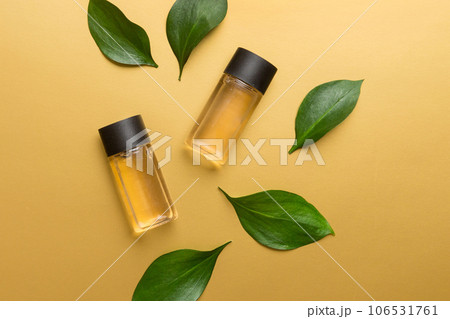 Organic cosmetic products with green leaves on color background. Copy space, flat lay Organic cosmetic products with green leaves on color background. Copy space, flat lay 106531761