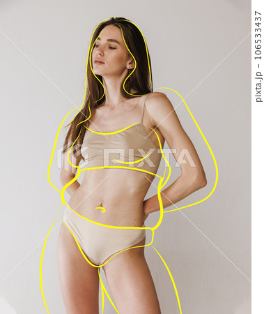 Portrait of posing fit girl in lingerie with drawn silhouette overweight woman around body against studio background. Health care. Portrait of posing fit girl in lingerie with drawn silhouette overweight woman around body against studio background. Health care. 106533437