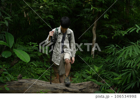 Young man with backpack trekking in forest, enjoying his recreation time in nature. Traveling and adventure concept 106534998
