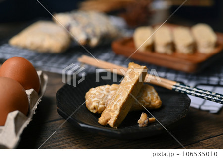 Close up of sliced homemade tempeh on black plate, healthiest alternative plant protein for Vegan and Plant based diet. 106535010