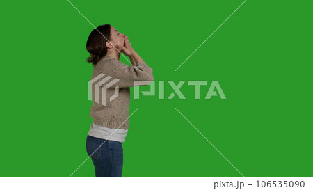 Profile of lovely person blowing kisses on camera to show love, expressing romantic feelings and optimistic emotions. Young adult acting confident and cheerful, being friendly on studio backdrop. 106535090