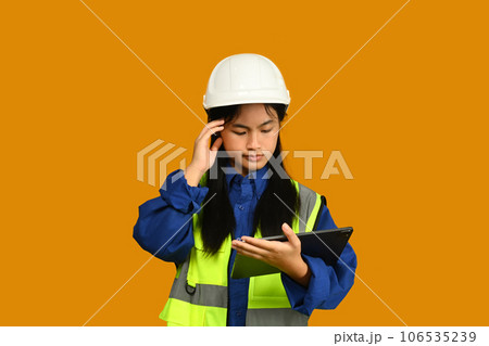 Asian girl holding helmet isolated on yellow background, future dream job career as engineer and architect Asian girl holding helmet isolated on yellow background, future dream job career as engineer and architect 106535239