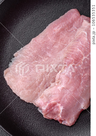 A piece of fresh juicy raw pork with salt, spices and herbs A piece of fresh juicy raw pork with salt, spices and herbs 106535351