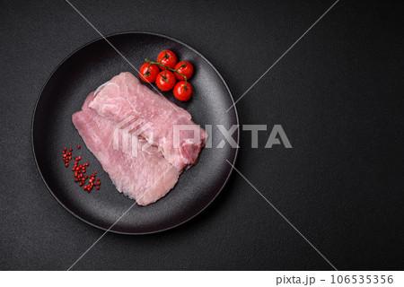 A piece of fresh juicy raw pork with salt, spices and herbs 106535356