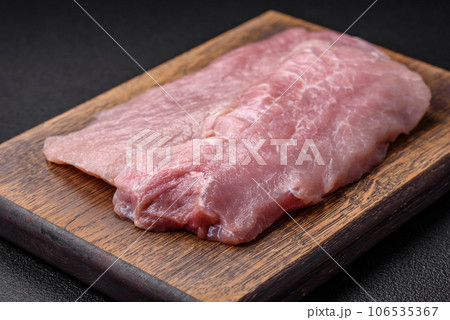 A piece of fresh juicy raw pork with salt, spices and herbs A piece of fresh juicy raw pork with salt, spices and herbs 106535367