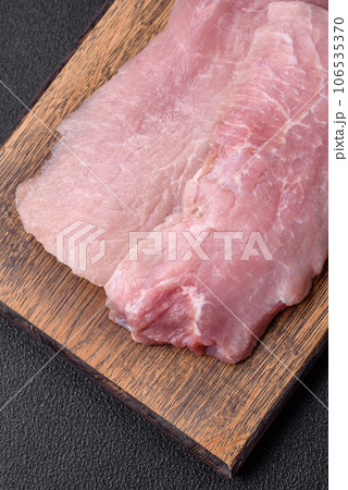 A piece of fresh juicy raw pork with salt, spices and herbs A piece of fresh juicy raw pork with salt, spices and herbs 106535370