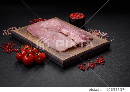 A piece of fresh juicy raw pork with salt, spices and herbs A piece of fresh juicy raw pork with salt, spices and herbs 106535374