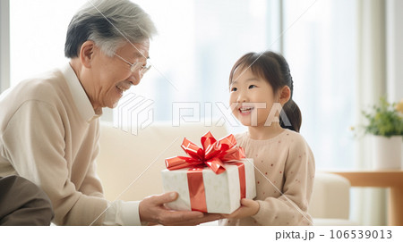 お祖父さんにプレゼントを渡す女の子 106539013
