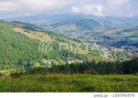pasture on the hills of mountainous countryside. beautiful rural landscape of transcarpathia, ukraine. village in the distant valley 106540979