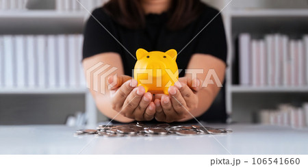 Man hand holding piggy bank on wood table, saving money wealth and financial concept, Business, finance, investment, financial planning Man hand holding piggy bank on wood table, saving money wealth and financial concept, Business, finance, investment, financial planning 106541660