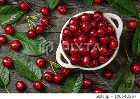 Fresh sweet cherries bowl with leaves on wooden desktop table. water drops on Fresh sour cherry sakura berries Fresh sweet cherries bowl with leaves on wooden desktop table. water drops on Fresh sour cherry sakura berries 106543267