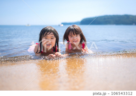 夏の浜辺で遊ぶ姉妹 106543312