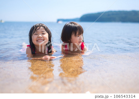 夏の浜辺で遊ぶ姉妹 106543314