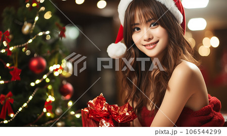 サンタ姿の女性とクリスマスプレゼント サンタ姿の女性とクリスマスプレゼント 106544299