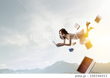 Young woman levitates while reading a book 106546053