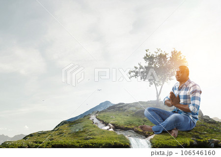 Young black man sitting and meditating 106546160