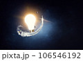 Light bulb glowing in darkness 106546192