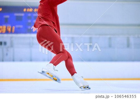 Speed and techniques of movements. Cropped image of female legs in motion, figure skating athlete on ice rink arena Speed and techniques of movements. Cropped image of female legs in motion, figure skating athlete on ice rink arena 106546355