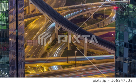Aerial view from above to a busy road junction in Dubai night timelapse. Aerial view from above to a busy road junction in Dubai night timelapse. 106547338