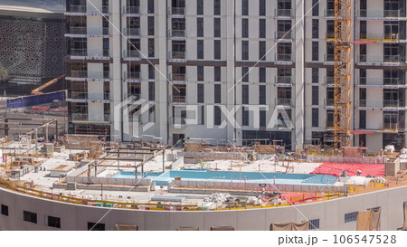 Swimming pool construction site with on the rooftop of parking with many workers aerial timelapse. Swimming pool construction site with on the rooftop of parking with many workers aerial timelapse. 106547528